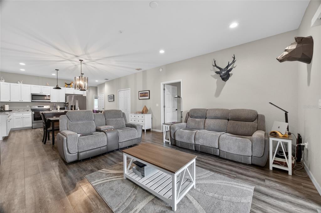 3415 West Anthony Road, Unit 303 Ocala, FL 34475 - Photo 14 of 29 a living room with furniture a kitchen view and a chandelier
