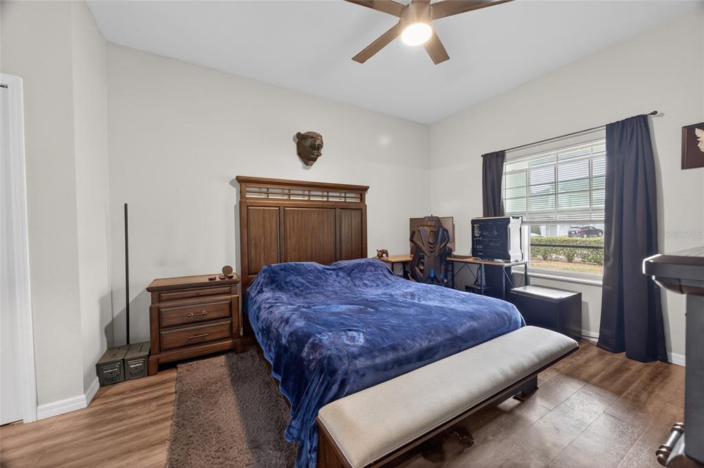 3415 West Anthony Road, Unit 303 Ocala, FL 34475 - Photo 15 of 29 a bedroom with a bed and dresser with wooden floor