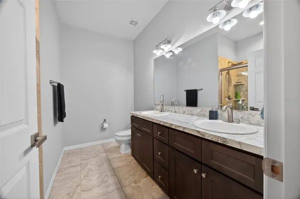a bathroom with a granite countertop sink a toilet and a mirror