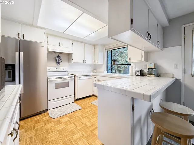 a kitchen with granite countertop a sink appliances cabinets and counter space