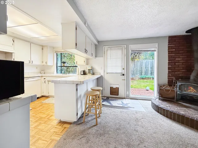 a living room with a couch a flat screen tv and a refrigerator