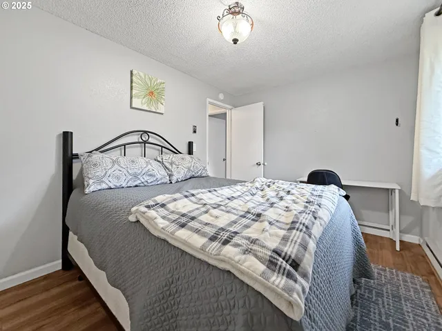 a bedroom with a bed and dresser with mirror