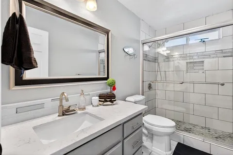 a bathroom with a sink vanity mirror and toilet
