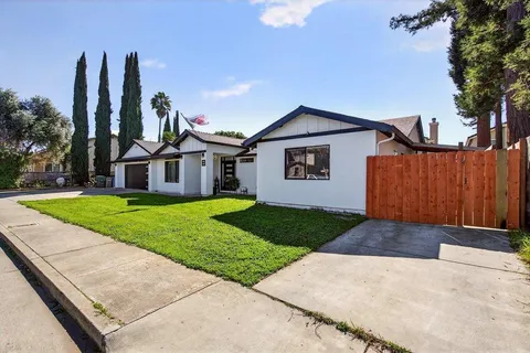 a front view of a house with a yard and trees