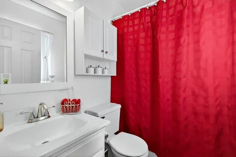 a bathroom with a sink a toilet and a mirror