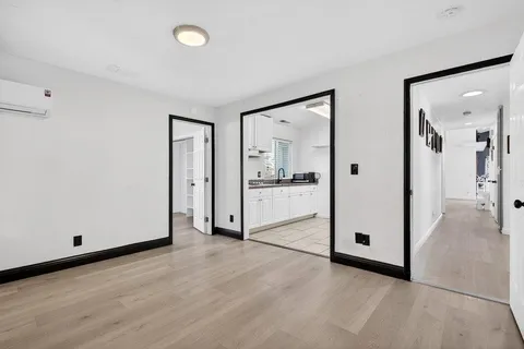 a view of empty room with wooden floor
