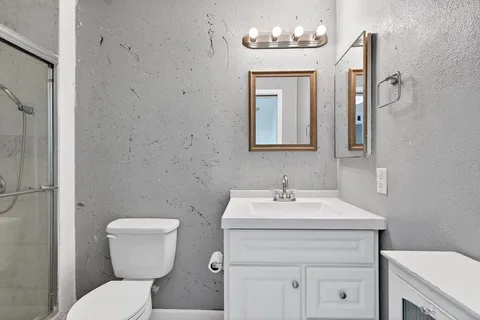 a bathroom with a toilet sink and mirror