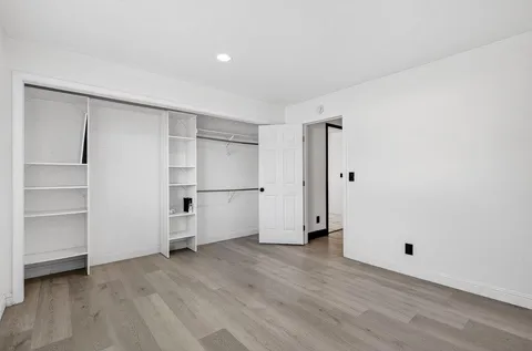 a view of empty room with wooden floor and cabinet