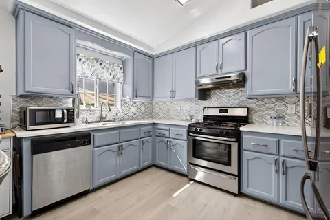 a kitchen with stainless steel appliances granite countertop a stove and a sink