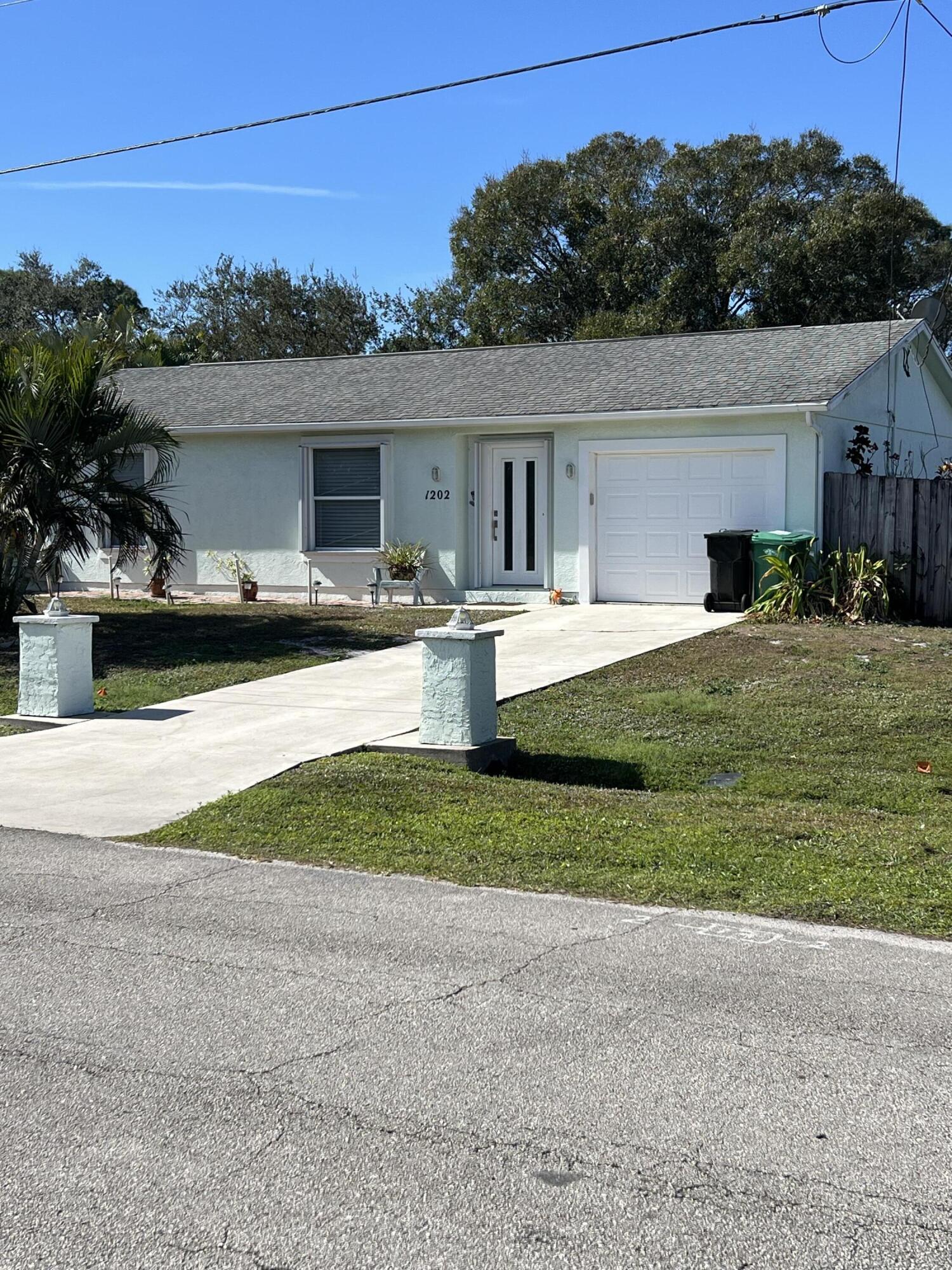 1202 Southwest Heather Street Port St. Lucie, FL 34983 - Photo 2 of 3 a view of a house with backyard and garden