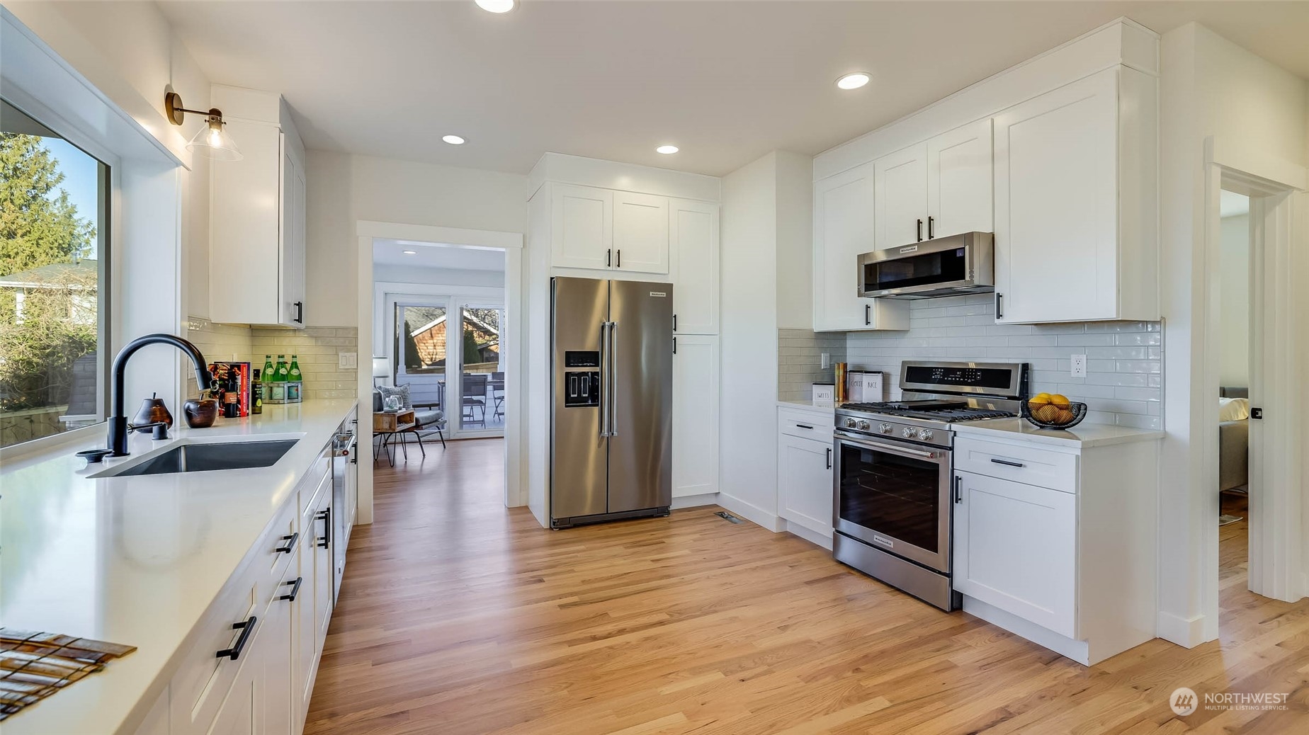 1018 North 34th Street Renton, WA 98056 - Photo 17 of 40 a kitchen with stainless steel appliances a sink dishwasher a refrigerator and a stove with wooden floor