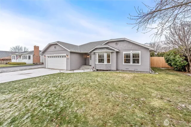 a view of a house with a yard and large trees