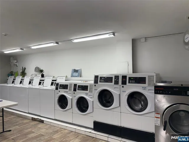 a utility room with dryer washer and wooden floor