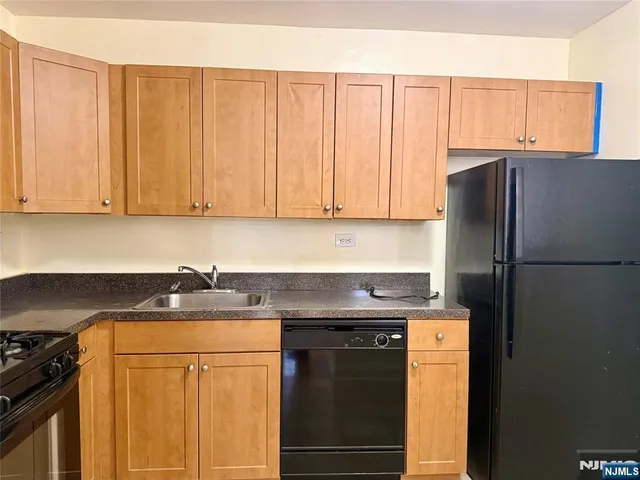 a kitchen with stainless steel appliances granite countertop a refrigerator stove and sink