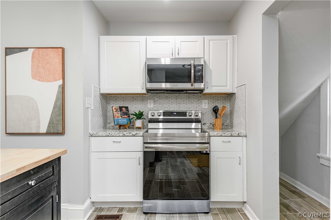 3103 Letcher Avenue Richmond, VA 23222 - Photo 24 of 50 a kitchen with stainless steel appliances granite countertop a stove a microwave and a refrigerator