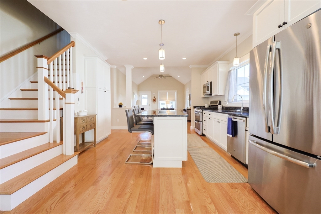 47 Compass Point Drive, Unit 47 Douglas, MA 01516 - Photo 12 of 32 a large open kitchen with stainless steel appliances granite countertop a refrigerator a oven a dining table and chairs with wooden floor