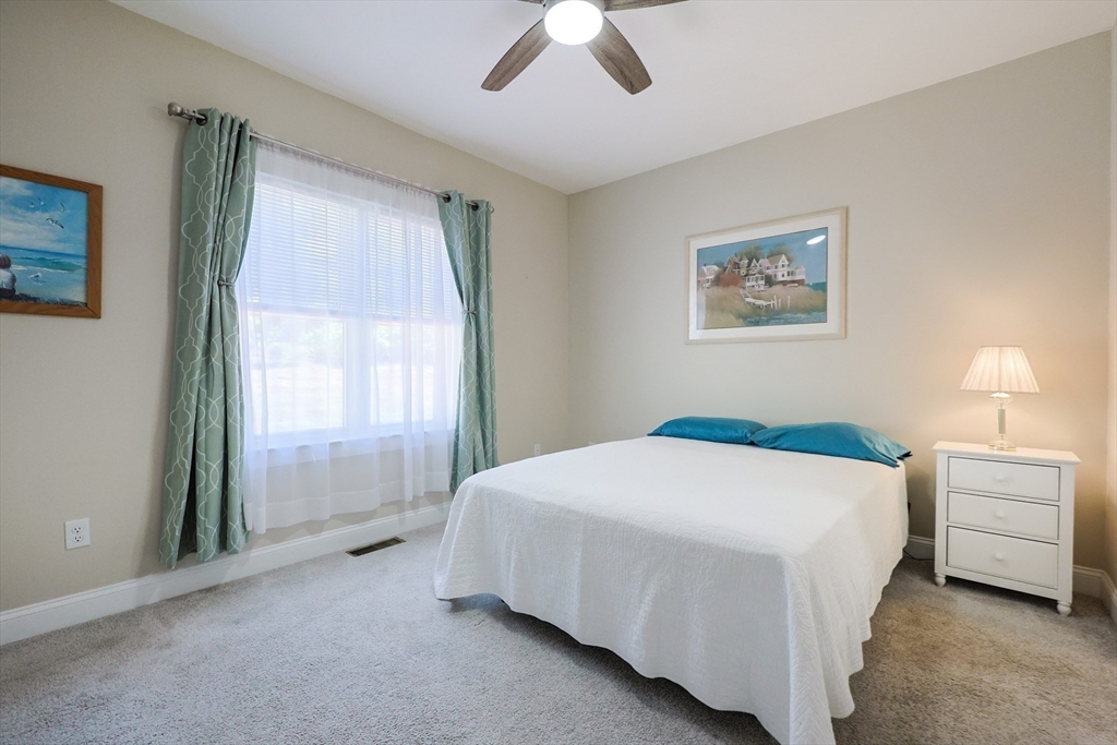 47 Compass Point Drive, Unit 47 Douglas, MA 01516 - Photo 14 of 32 a bedroom with a bed and a chandelier