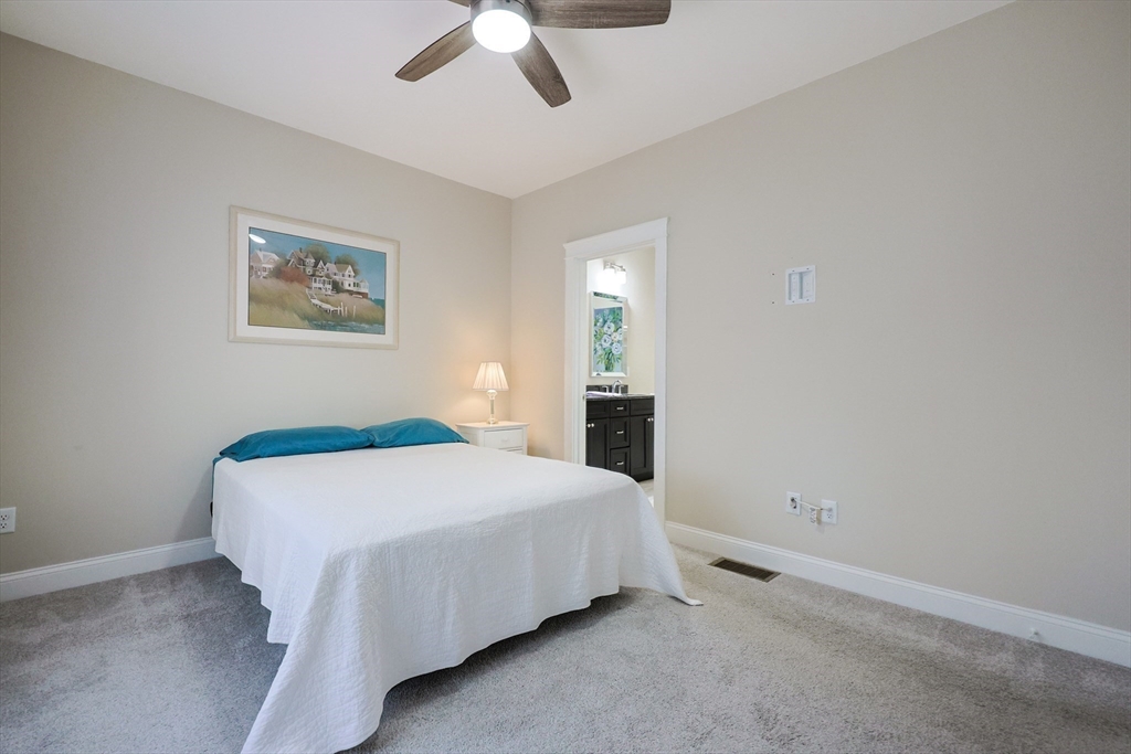 47 Compass Point Drive, Unit 47 Douglas, MA 01516 - Photo 15 of 32 a bedroom with a bed and a ceiling fan