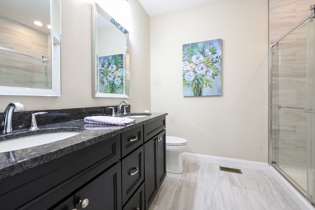 47 Compass Point Drive, Unit 47 Douglas, MA 01516 - Photo 16 of 32 a bathroom with a granite countertop sink mirror vanity and toilet