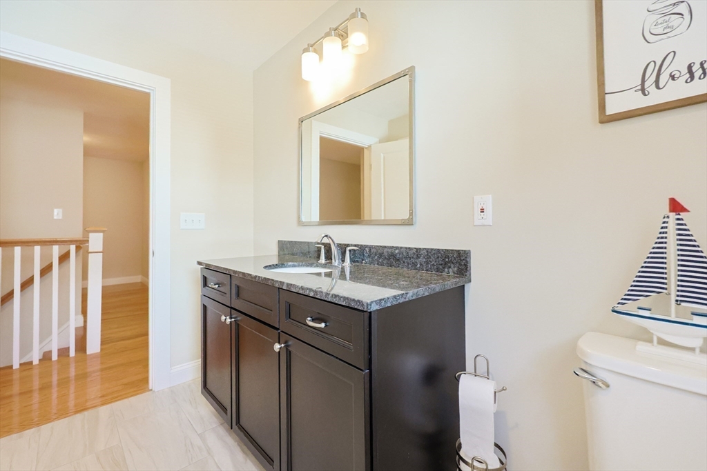 47 Compass Point Drive, Unit 47 Douglas, MA 01516 - Photo 23 of 32 a bathroom with a granite countertop sink a toilet and a mirror