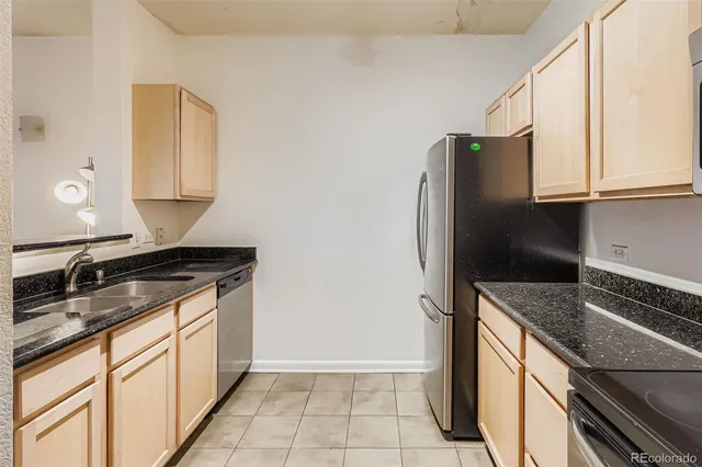 a kitchen with granite countertop a refrigerator and a sink
