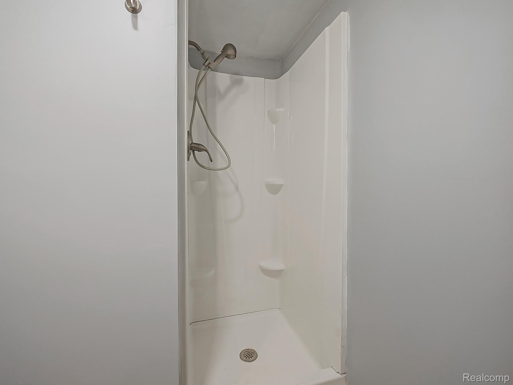 42195 Park Ridge Road Novi, MI 48375 - Photo 36 of 52 White shower enclosure with integrated shelving and a bronze-finish shower head