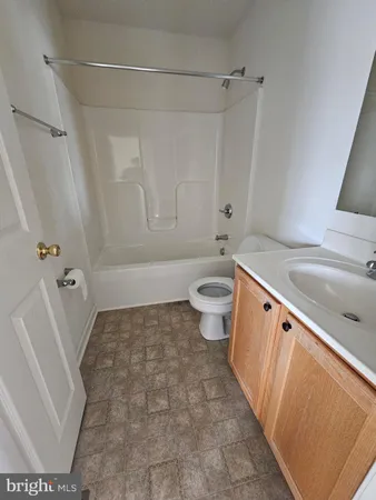 a bathroom with a sink a toilet a window and tub