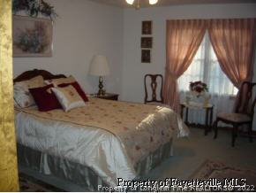 7775 Dragonhead Road Fayetteville, NC 28311 - Photo 11 of 12 a bedroom with a bed a dresser and next to a window