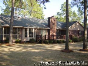 7775 Dragonhead Road Fayetteville, NC 28311 - Photo 2 of 12 a view of a brick house with large windows and a small yard