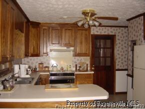 7775 Dragonhead Road Fayetteville, NC 28311 - Photo 8 of 12 a kitchen with kitchen island granite countertop a refrigerator a stove and a sink