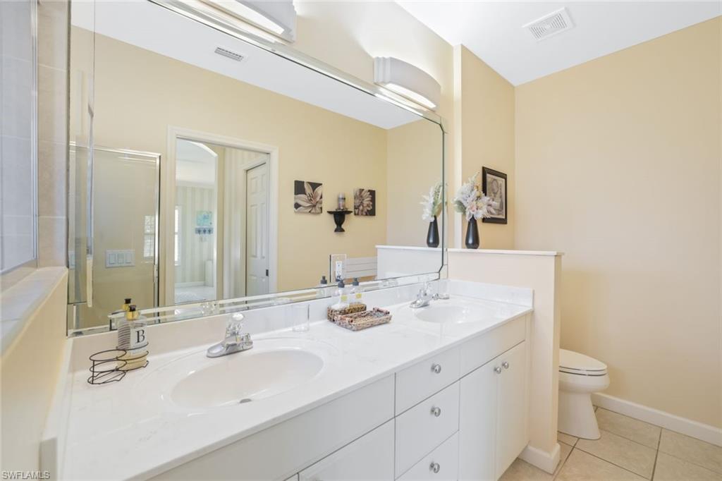 3047 Horizon Lane, Unit 1908 Naples, FL 34109 - Photo 11 of 17 Bathroom with vanity, toilet, an enclosed shower, and tile patterned flooring
