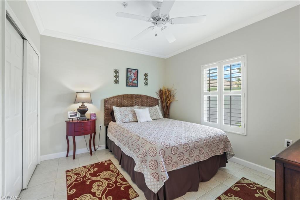 3047 Horizon Lane, Unit 1908 Naples, FL 34109 - Photo 14 of 17 Bedroom featuring a closet, ceiling fan, light tile patterned floors, and crown molding
