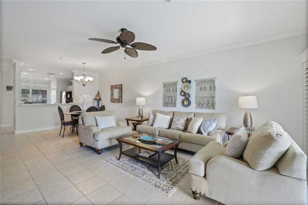 3047 Horizon Lane, Unit 1908 Naples, FL 34109 - Photo 2 of 17 Tiled living room featuring ornamental molding and ceiling fan with notable chandelier