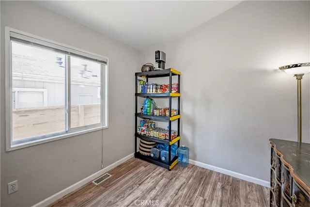 a view of a room that has a window and wooden floor
