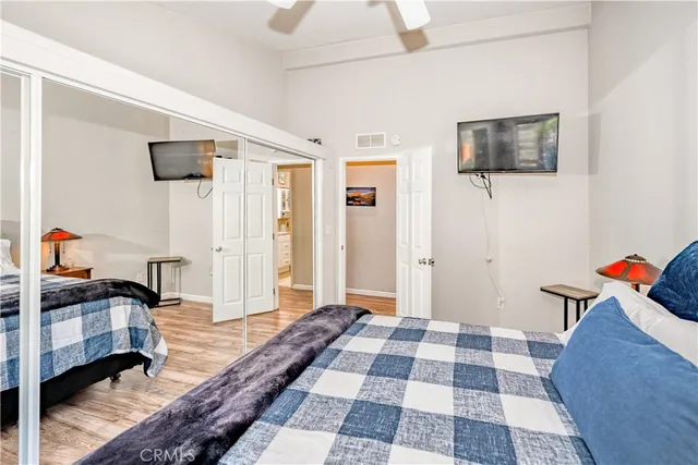 a bedroom with a bed and a mirror on the dresser