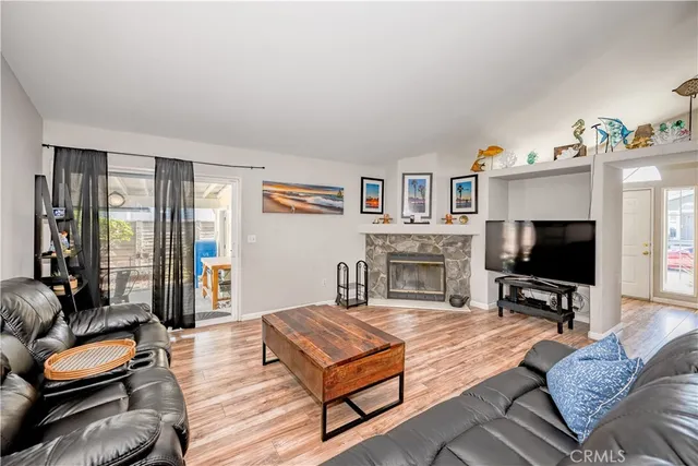 a living room with furniture a flat screen tv and a fireplace