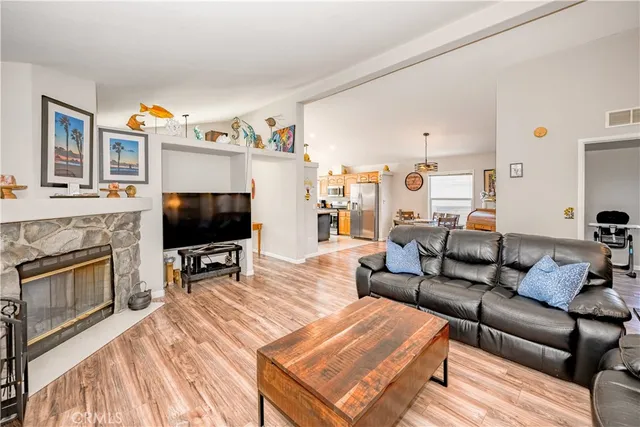 a living room with furniture a flat screen tv and kitchen view