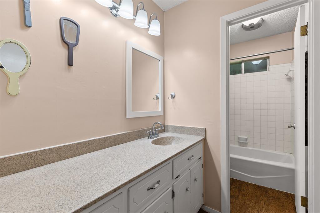 505 Pinewood Lane Hewitt, TX 76643 - Photo 25 of 38 Extended vanity with a built-in sink, framed mirror, and chrome light fixture
