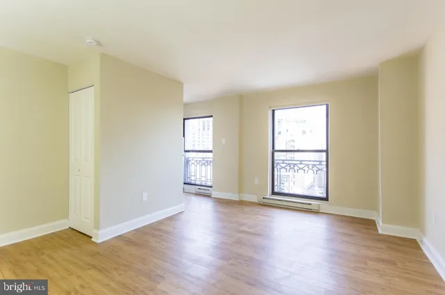 an empty room with wooden floor and window