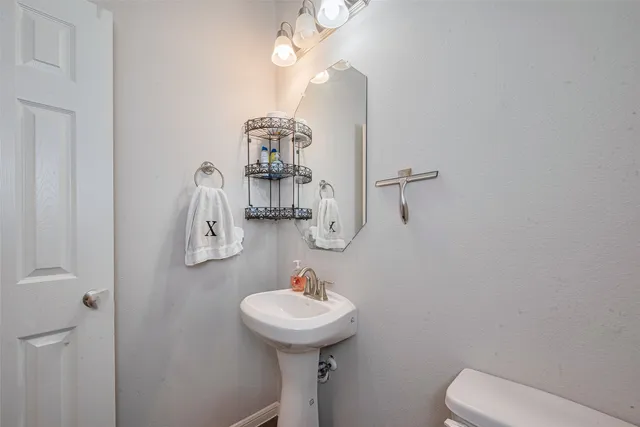 a bathroom with a sink a toilet and mirror