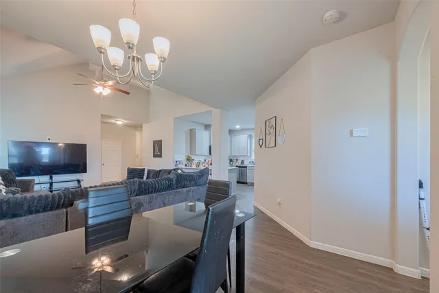 a living room with furniture a chandelier and a flat screen tv