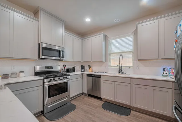 a kitchen with a sink stove and white cabinets
