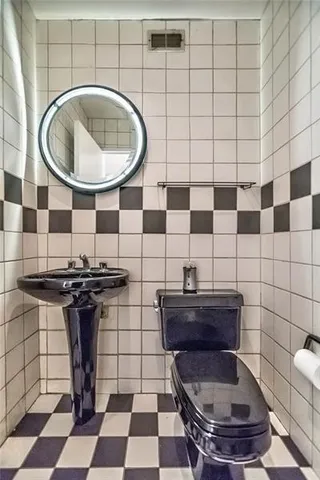 a bathroom with a toilet a sink and a mirror