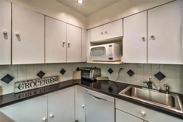 a kitchen with stainless steel appliances granite countertop white cabinets a sink and dishwasher