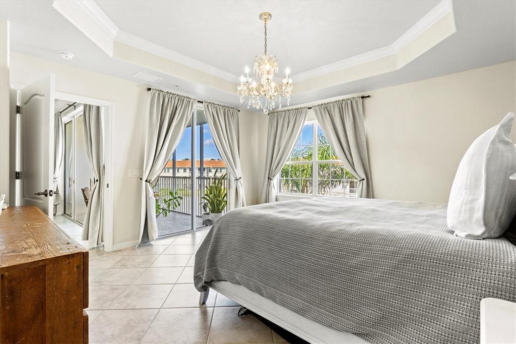 1000 San Lino Circle, Unit 1032 Venice, FL 34292 - Photo 27 of 88 a bedroom with a bed and a chandelier