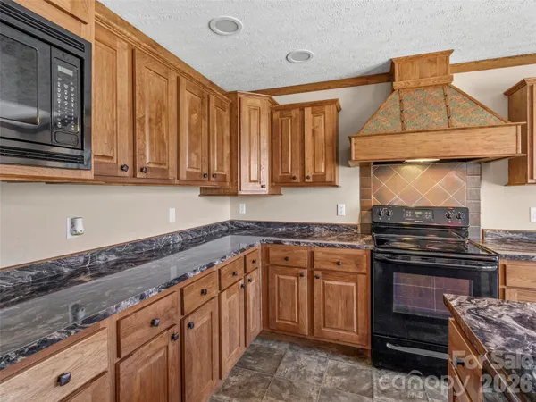 a kitchen with stainless steel appliances granite countertop a stove and a microwave