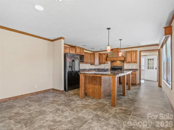 a kitchen with stainless steel appliances kitchen island granite countertop a refrigerator and a stove top oven