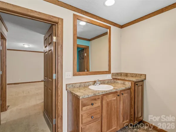 a bathroom with a granite countertop sink and a mirror