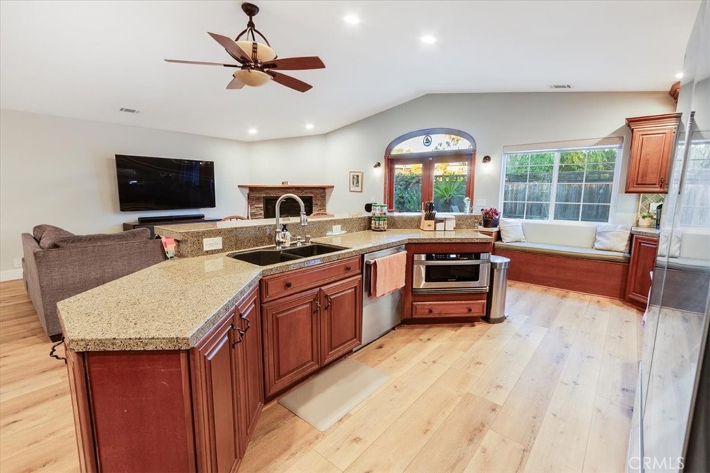 9541 Mandeville Road Santee, CA 92071 - Photo 8 of 46 a open kitchen with stainless steel appliances granite countertop a stove top oven a sink dishwasher a dining table and chairs with wooden floor
