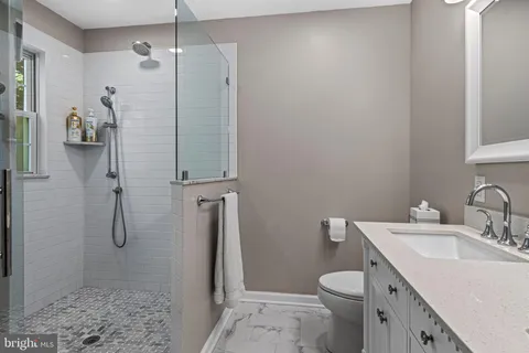 a bathroom with a granite countertop sink a toilet and a mirror